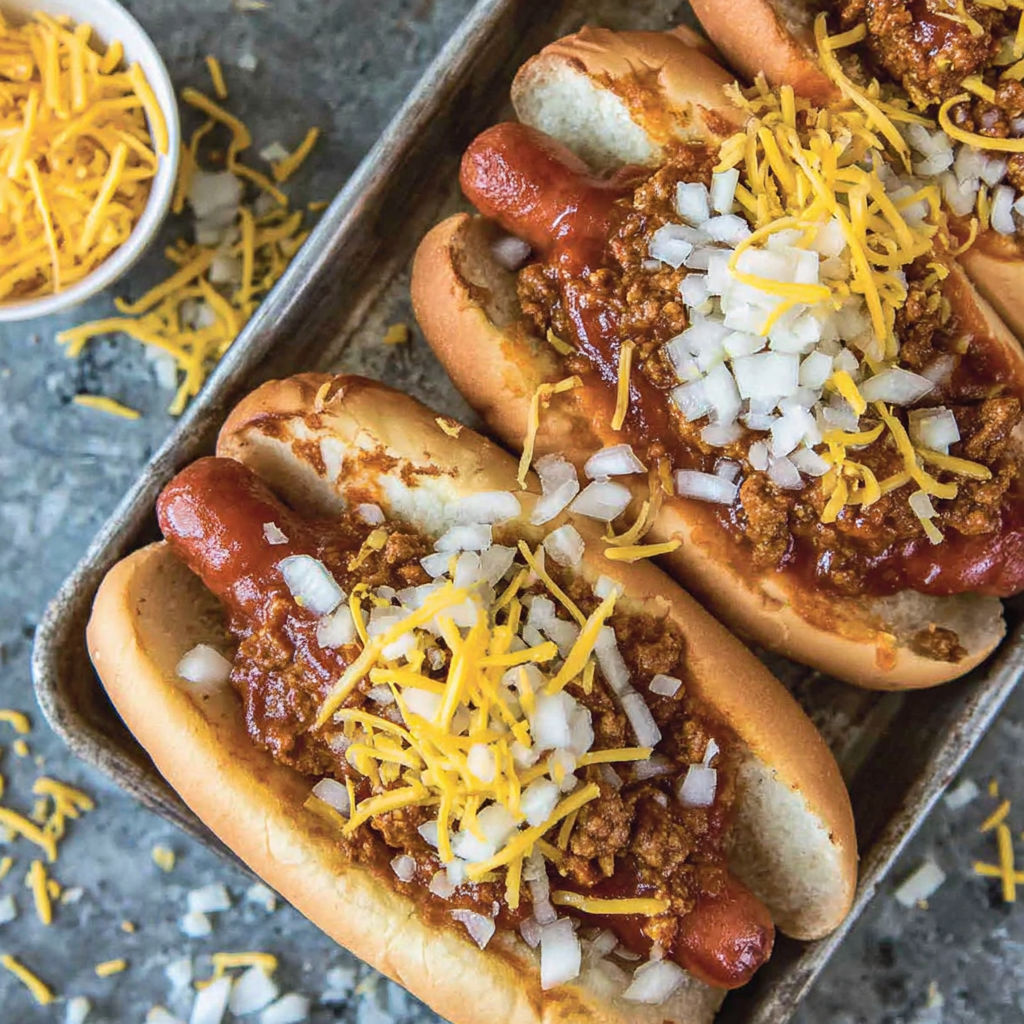 Two chili cheese dogs with onions.