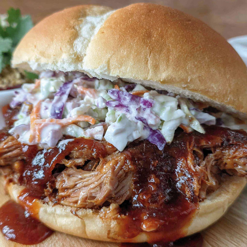 A pulled pork sandwich with coleslaw on a bun.