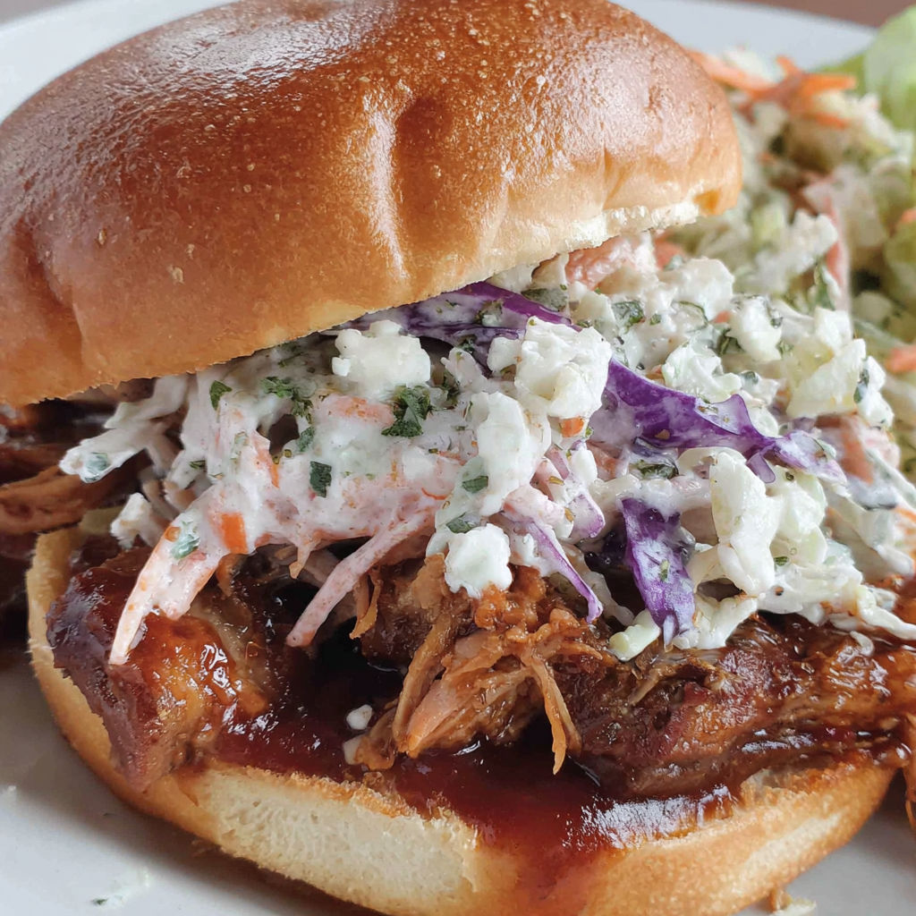 A sandwich with coleslaw on a bun.