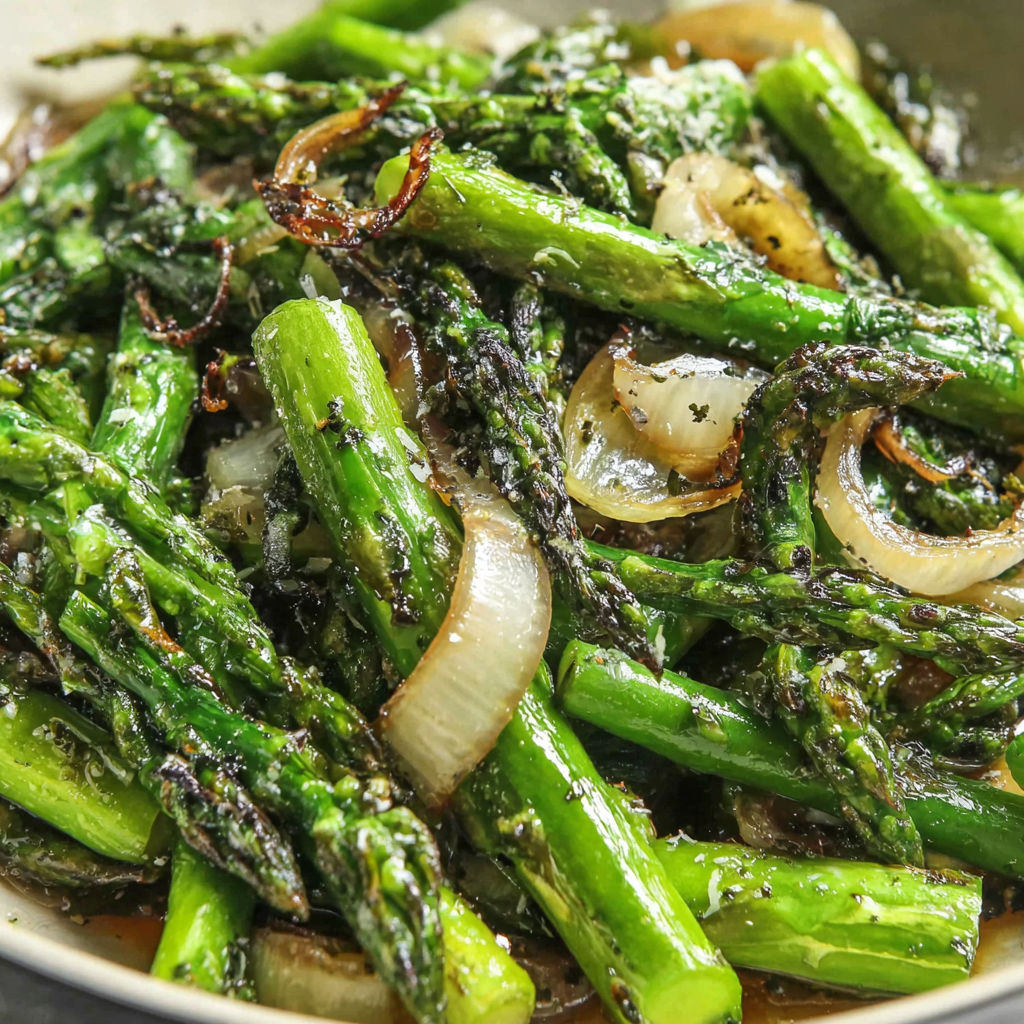 A bowl of cooked asparagus with onions and garlic.