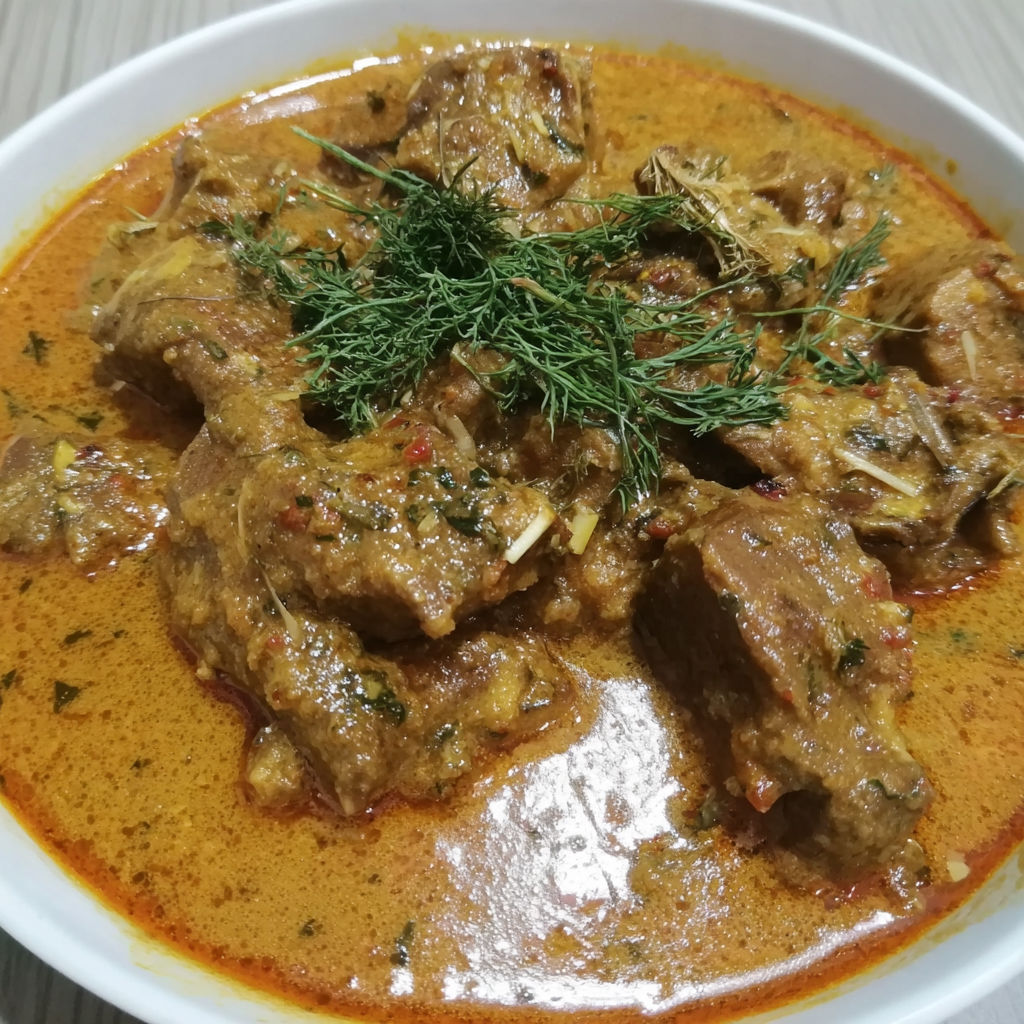 A bowl of mutton curry with a green garnish.