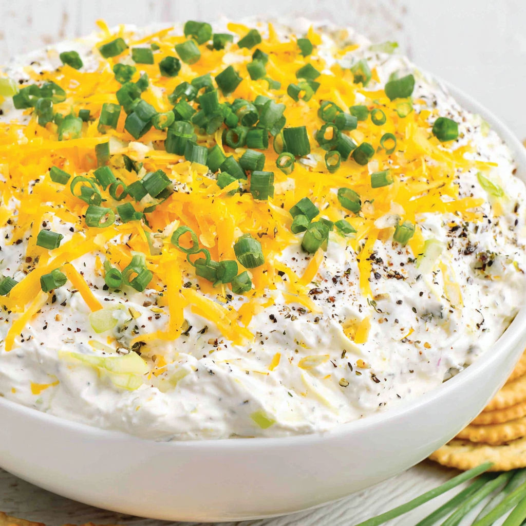 A bowl of food with cheese and chives.