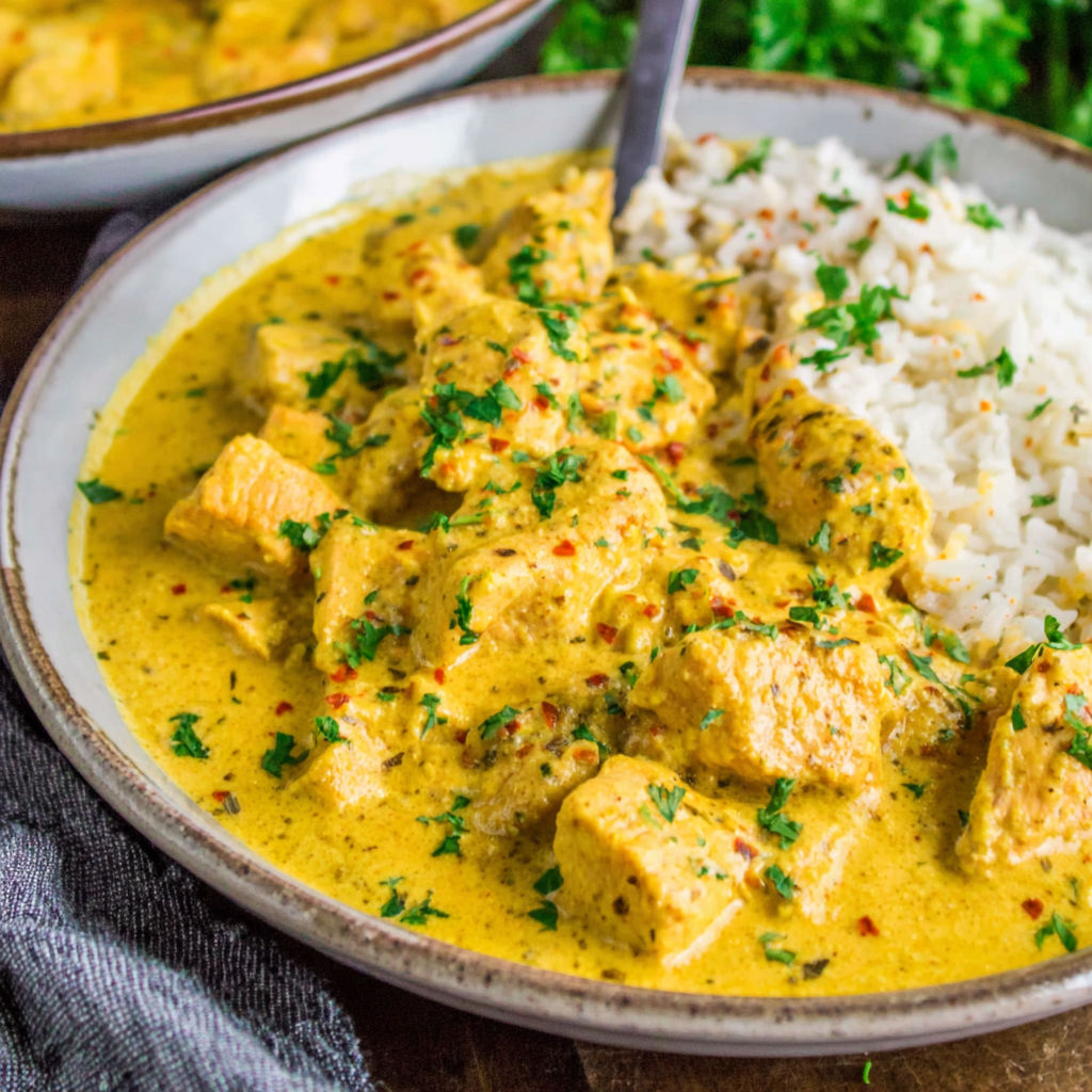 A plate of food with rice and meat in a creamy sauce.