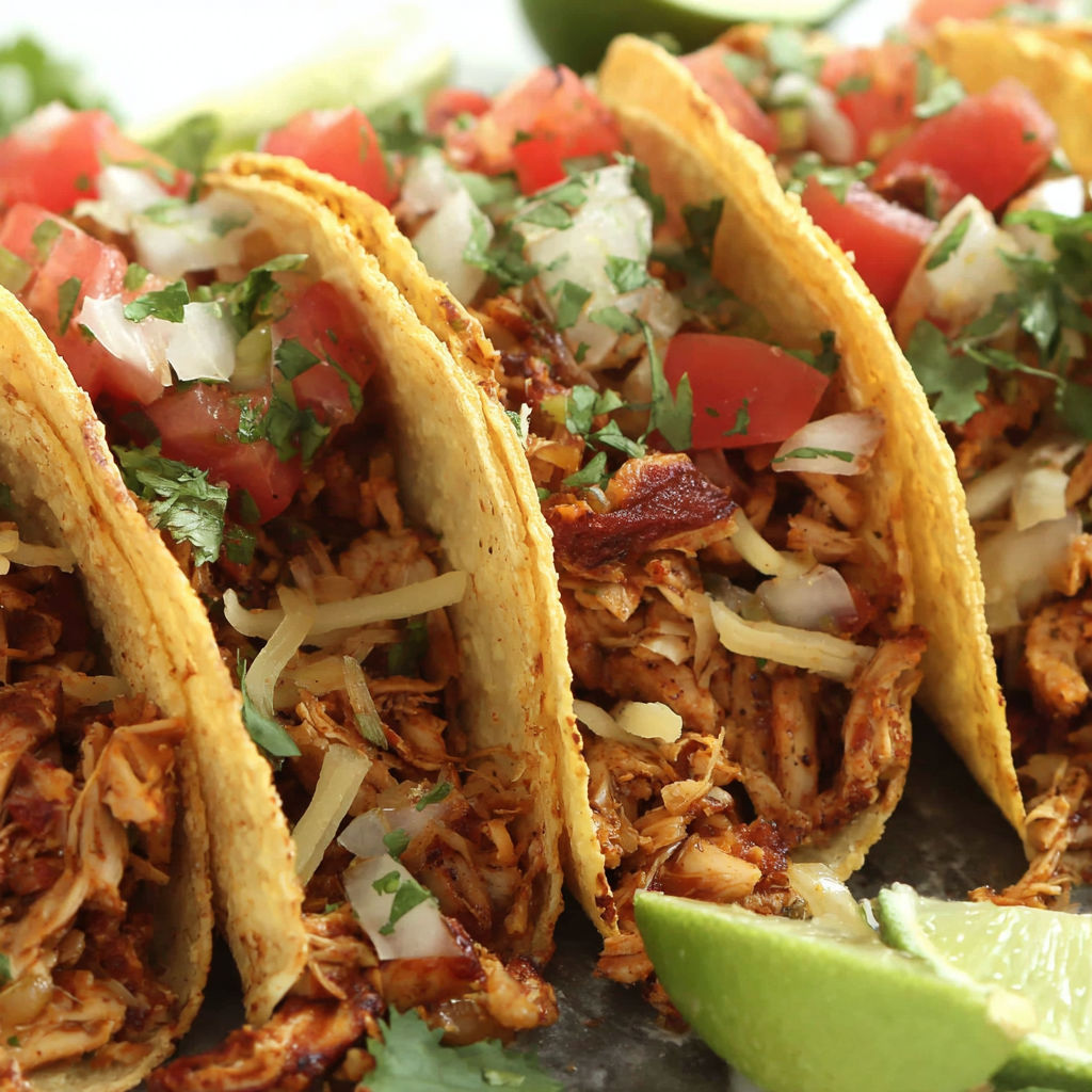 A plate of tacos with tofu meat and tomatoes.