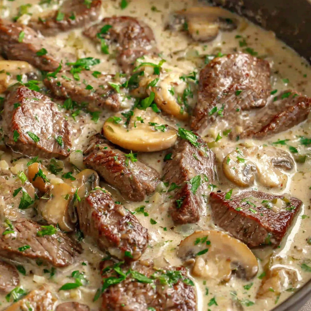 A bowl of beef stroganoff with mushrooms and herbs.