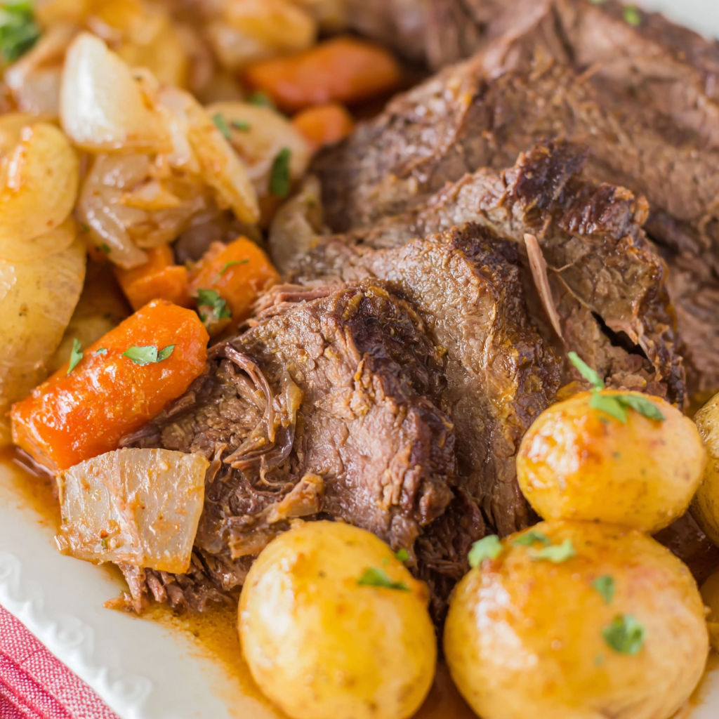 A plate of food with a roast and potatoes.