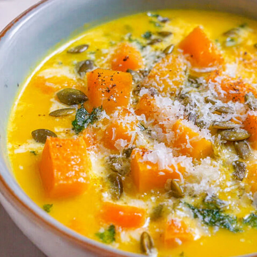 A bowl of soup with a variety of vegetables.