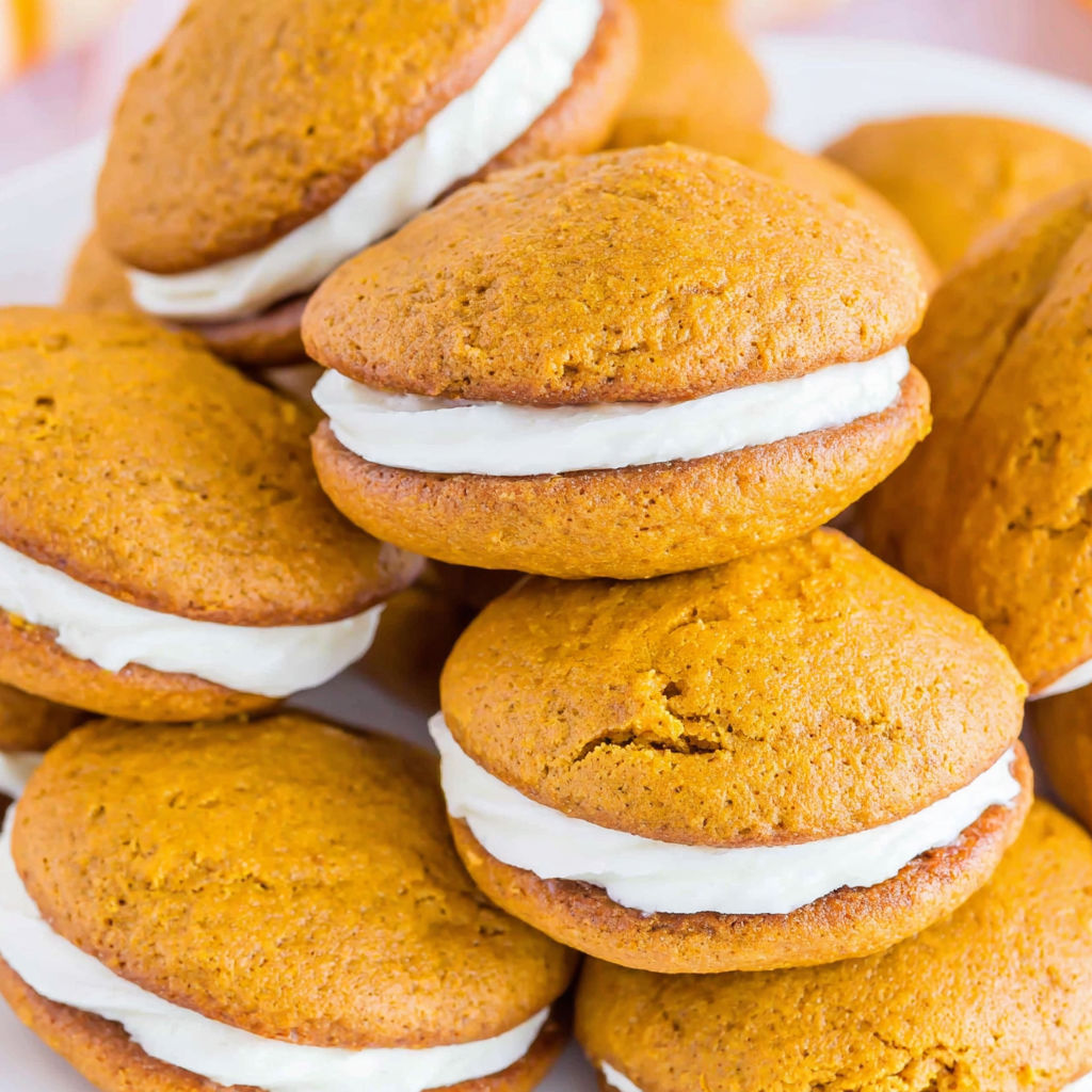 Pumpkin whoopie pies on a plate.