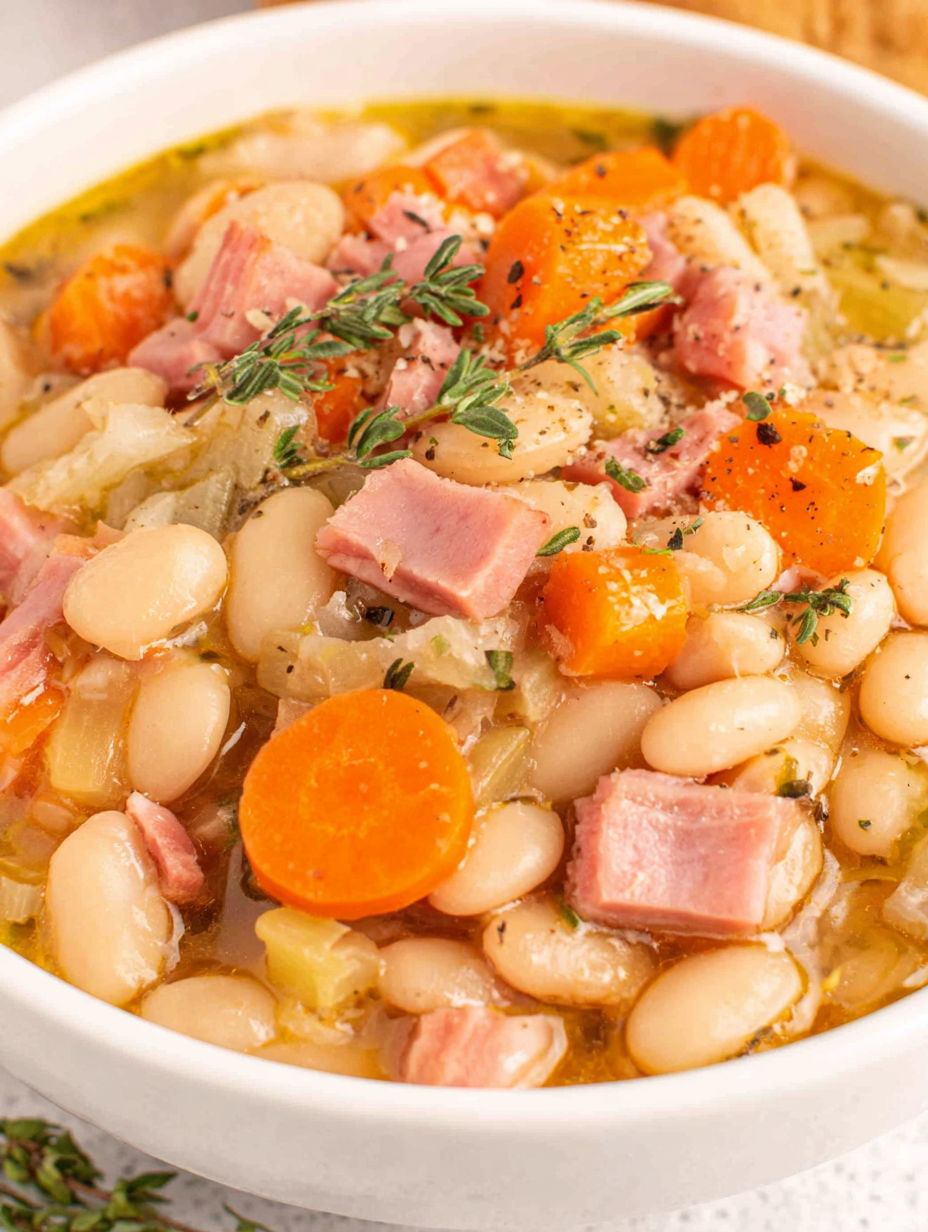 A bowl of soup with ham and beans.