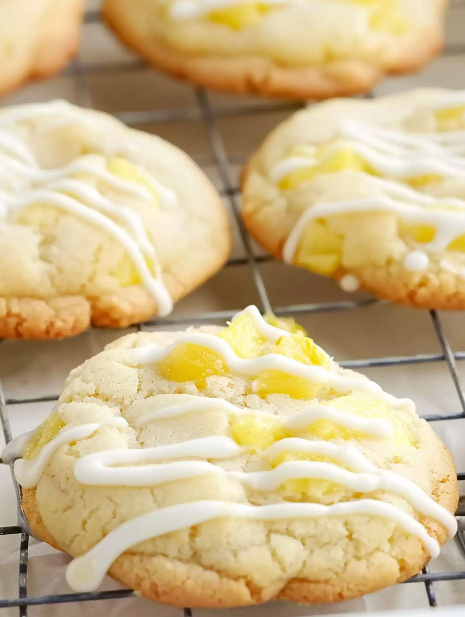 A tray of cookies with white icing and pineapple.