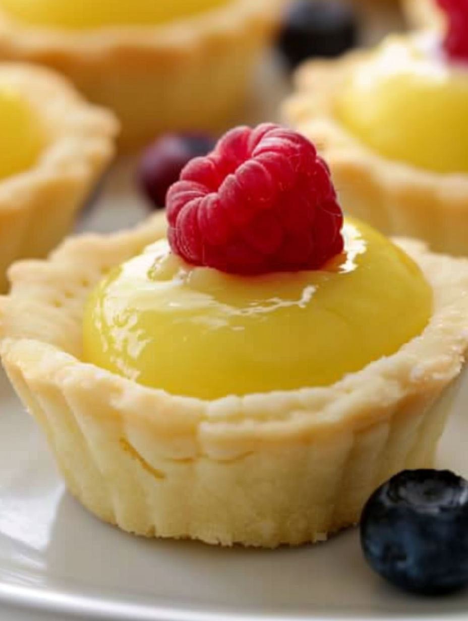 A small pastry with a raspberry on top.