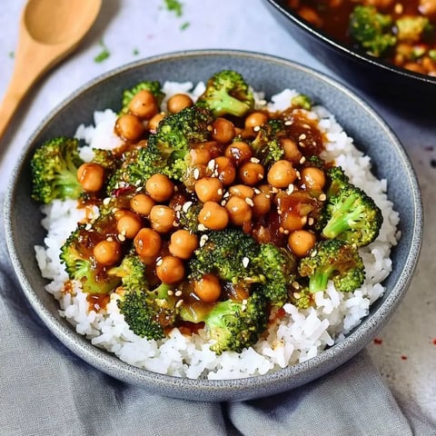 Eine Schale Reis mit Brokkoli, Kichererbsen und leckerer Sauce obendrauf.