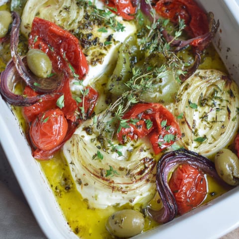 A dish of food with tomatoes, onions, and cheese.