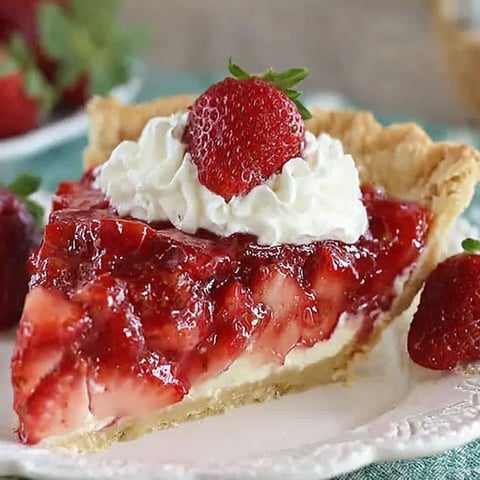 A slice of strawberry pie with whipped cream on top.