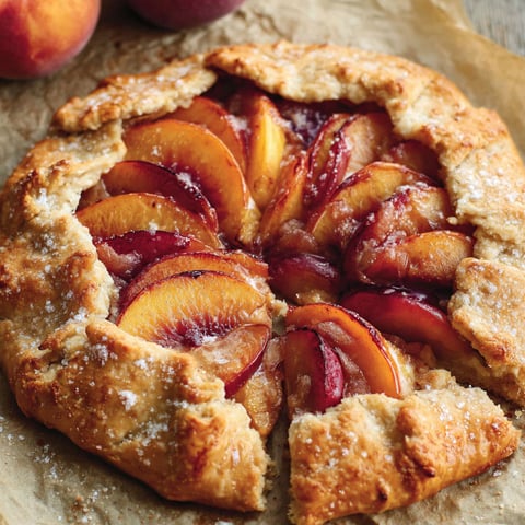 A peach galette recipe with a slice missing.