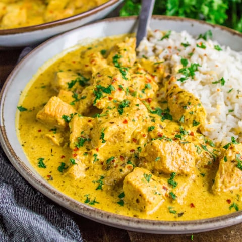 A plate of food with rice and meat in a creamy sauce.