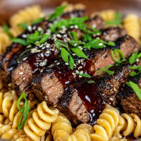 A plate of food with meat, noodles, and herbs.