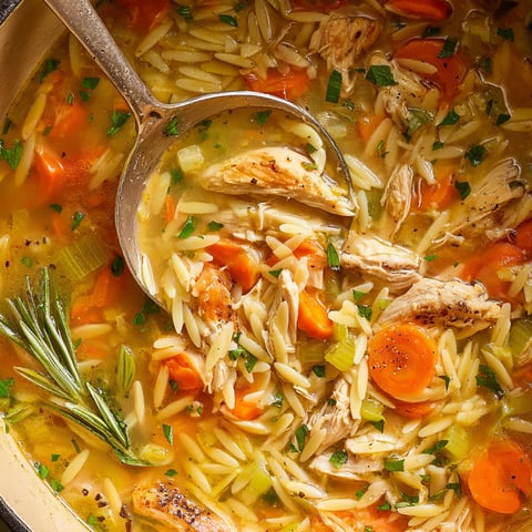 A bowl of soup with chicken and rice.