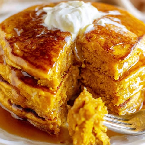 A slice of pumpkin pancakes with butter on top.