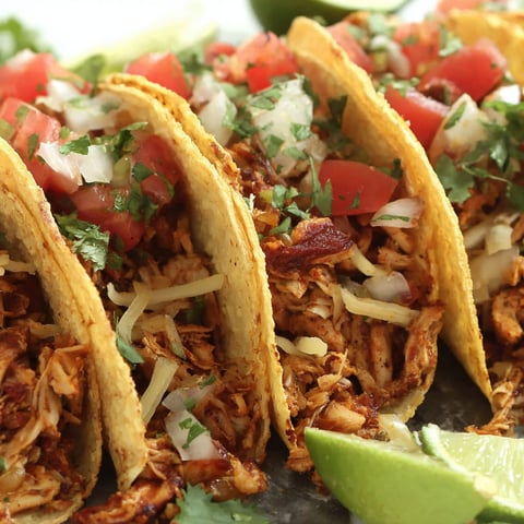 A plate of tacos with tofu meat and tomatoes.