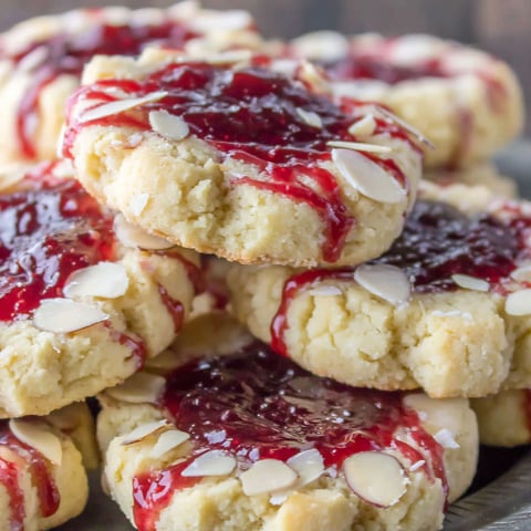 A stack of cookies with raspberry jam on top.