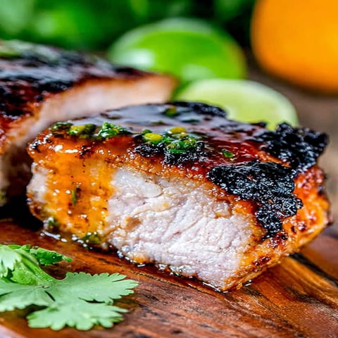 A piece of meat with a green herb on top.