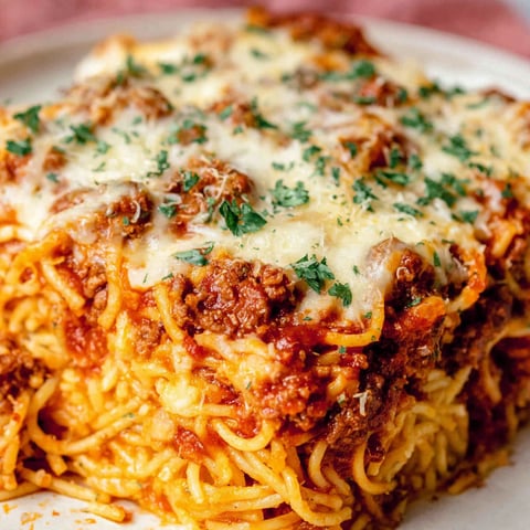 A close up of a spaghetti casserole with cheese and meat.