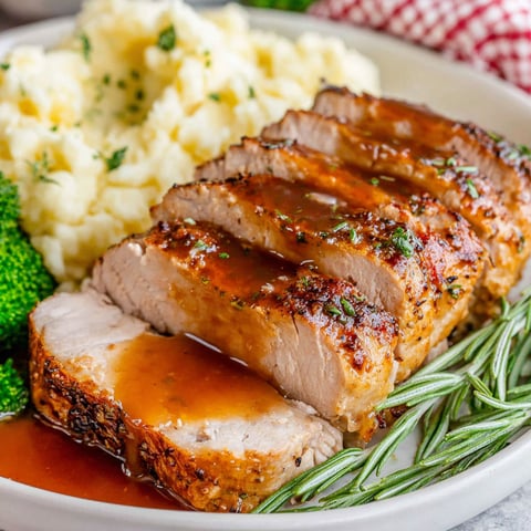 A plate of food with a pork loin roast and mashed potatoes.