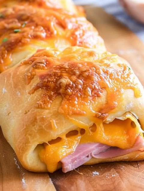 A close up of a hot ham and cheese roll.