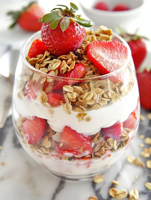 A glass of strawberry cheesecake breakfast parfait.