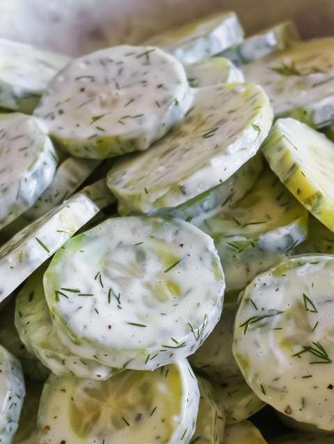 A pile of cucumber slices with a creamy dressing.