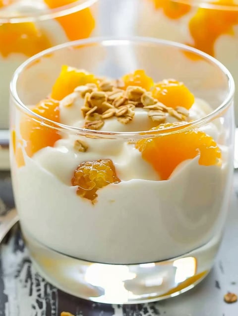 A glass of orange cream dessert.