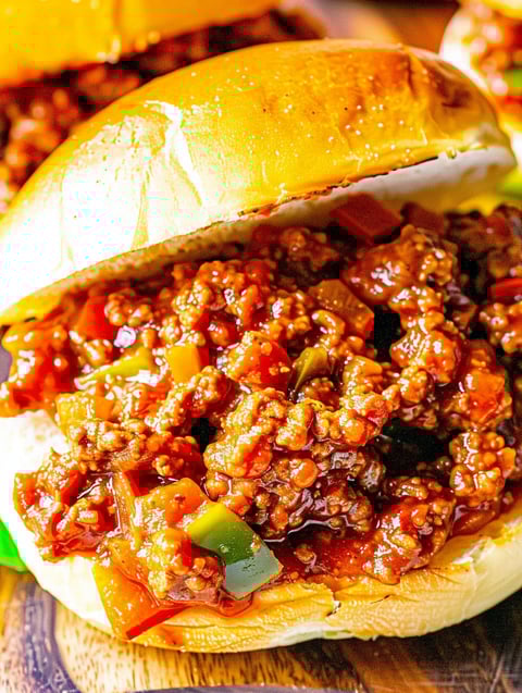 A sloppy joe sandwich with a bun and a green pepper.